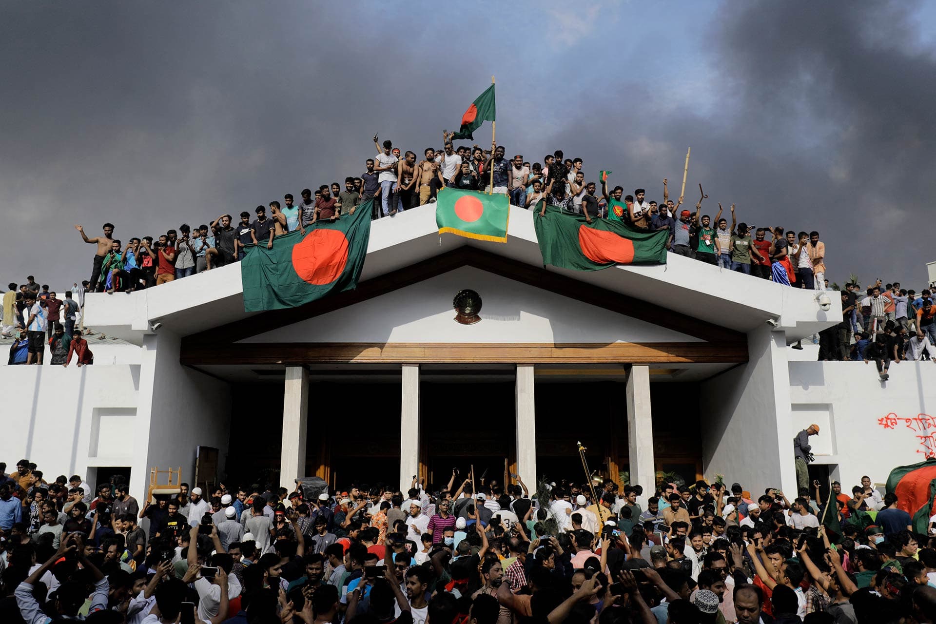 Manifestantes con banderas de Bangladesh irrumpen en el palacio de la primera ministra Sheikh Hasina en la capital Daca