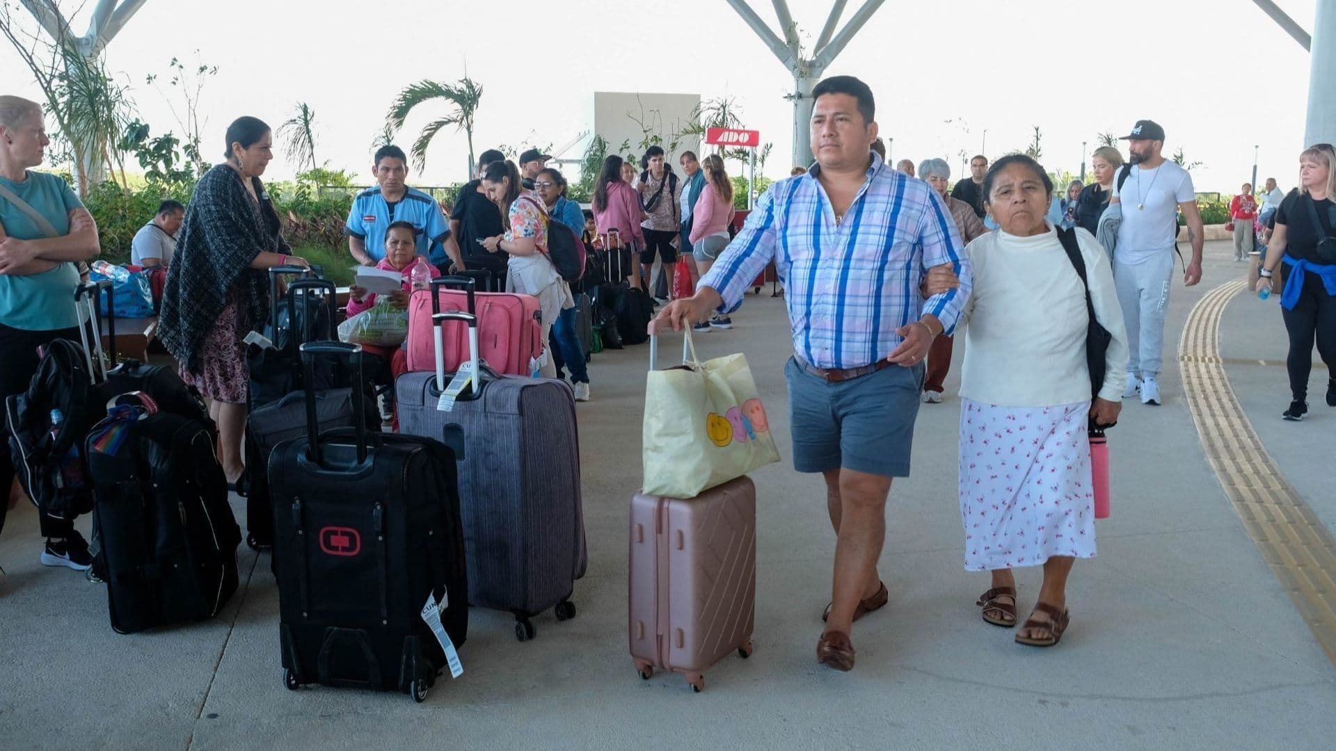 personas turistas caminan en estación del Tren Maya